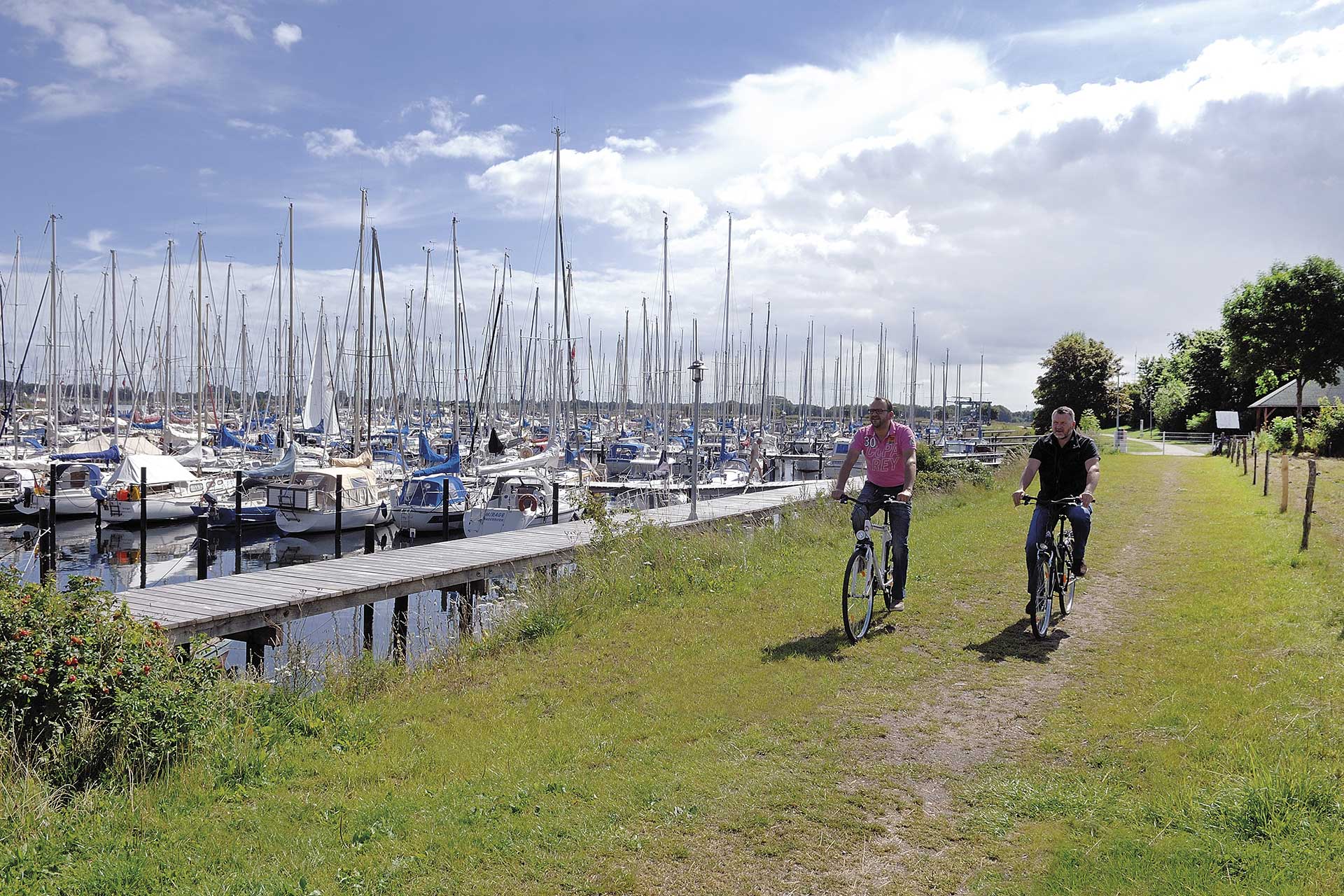 Bild Strandweg mit zwei Radfahrern am Hafen